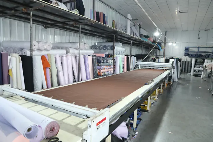 Vacuum CNC cutter cutting backpack panels from pink fabric